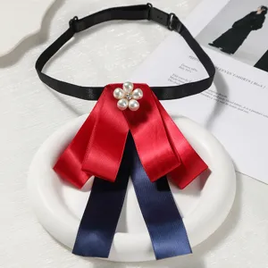 Vue détaillée de l'élégant nœud papillon rouge et bleu foncé avec broche fleur perle.