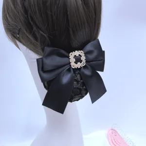 Professional hairnet bun cover with black satin bow and rhinestone buckle for work.