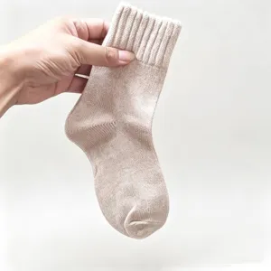 Beige knitted mid-tube socks detail shot, soft texture with ribbed cuff for daily comfort.