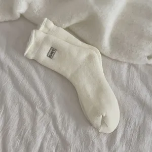 Close up detail of embroidered sweet wool-blend cozy mid-calf socks in classic white color for daily wear