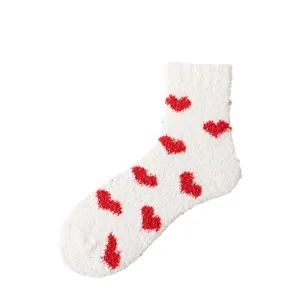 White fuzzy coral fleece socks featuring red heart patterns, cozy warm mid-tube winter socks.