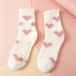 Fluffy coral fleece mid-tube socks featuring cute pink hearts on a soft white background.