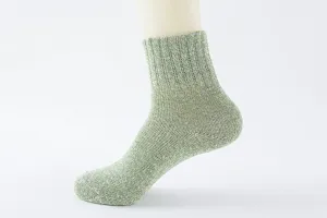 Detailaufnahme grüner Strick-Wollmisch-Wadenocken am Fußmodell, weiche warme Winterkleidung.