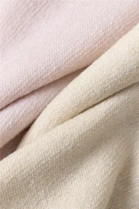 Detailopname van dik thermisch sokkenweefsel met zachte gebreide textuur in roze en beige.
