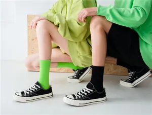 Einfarbige baumwollene Wadenfuesse Socken kombiniert mit klassischen Sneakers im Detail.