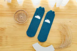 Close-up detail of soft blue fuzzy coral fleece sleep socks featuring cute rabbit ear design.