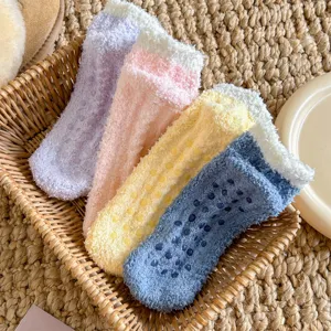Chaussettes de sol duveteuses en polaire corail avec picots antidérapants et bordure.