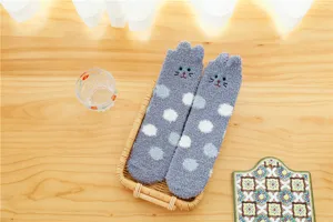 Cozy grey coral fleece sleep socks detail showing cute cat ears and soft polka dot texture.