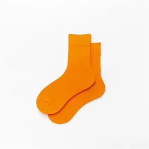Nahaufnahme Detailansicht leuchtend orangefarbener Baumwoll-Wadenstrümpfe aus weichem Material.