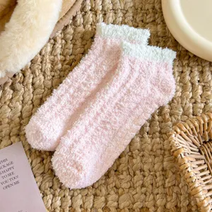 Chaussettes duveteuses en polaire corail rose et blanc avec détails de silicone.