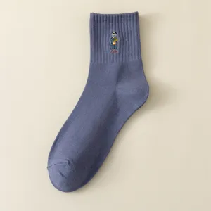 Gros plan sur le motif de personnage brode sur le tissu de chaussette bleue pour homme.