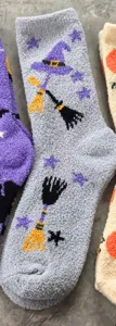 Close-up detail of cozy Halloween fuzzy socks with witch hat and broom motifs, soft plush texture.