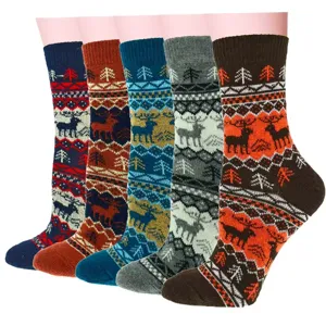 Nahaufnahme von Wintersocken aus Strick mit norwegischem Rentier- und Tannenmuster, bunt.