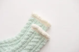 Chaussettes courtes douillettes en polaire corail pour femmes avec poignets blancs doux et chauds.