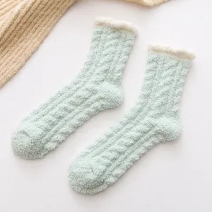 Gros plan de chaussettes douillettes vert clair avec revers duveteux blanc et texture en tricot.