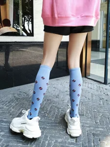 Women's blue knee-high socks featuring stylish geometric diamond pattern detail view.