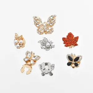 Detailed view of exquisite rhinestone scarf buckles and decorative clips in butterfly and leaf shapes.