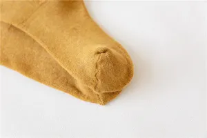 Winter thickened thermal cotton socks detail close-up, soft knit fabric in mustard yellow.