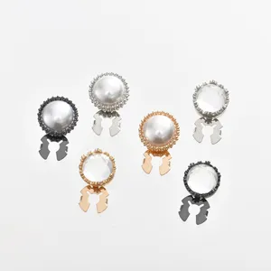 Close-up detail of elegant pearl and crystal rhinestone shirt cufflinks, versatile buttons.