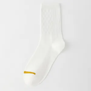 Chaussettes blanches pour hommes avec motif losanges et détail de rayure jaune au bout.