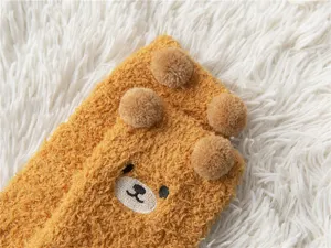 Detailed shot of cute bear plush coral fleece socks, soft warm thick fuzzy home floor socks.