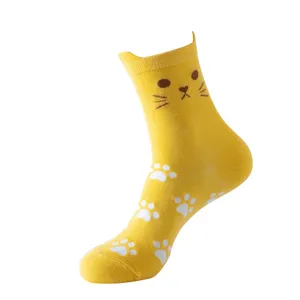 Close-up detail of yellow cat crew socks with cute paw prints and 3D cat ear design.