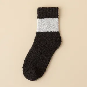 Gemütliche kuschelige Korallenfleece Wintersocken mit schwarz-weißem Streifenmuster.