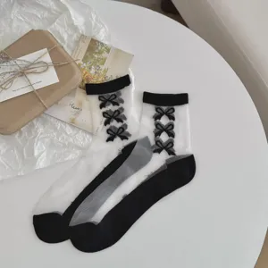 Chics chaussettes transparentes noir et blanc pour femmes avec adorables nœuds décoratifs.