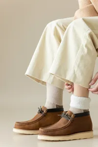 Primer plano detallado de calcetines de lana térmica con botas vintage y pantalón.