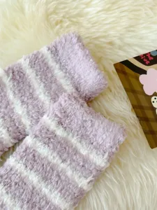 Detail view displaying the soft texture and purple striped pattern of plush winter sleep socks.