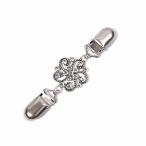 Detailed shot of silver tone rhinestone floral cardigan clip, exquisite filigree metal.