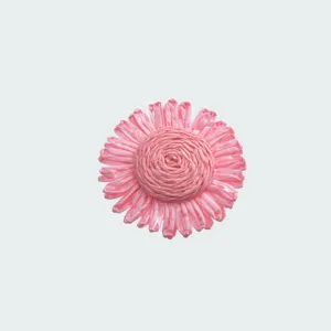 Dettaglio bottone floreale rosa, forma di fiore tessuta per delicata decorazione di vestiti.