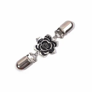 Detailed view of metal cardigan clip with black enamel rose flower, elegant shawl accessory
