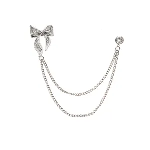 Silver rhinestone bow brooch with double hanging chains, elegant lapel pin for suit outfits.