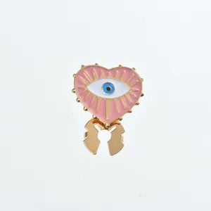 Detailed shot of a trendy evil eye collar clip, pink heart enamel with gold finish accent.