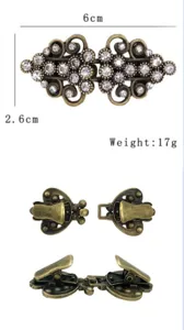 Detail view of vintage rhinestone metal cloak clasp and sweater clip with secure duckbill clips.