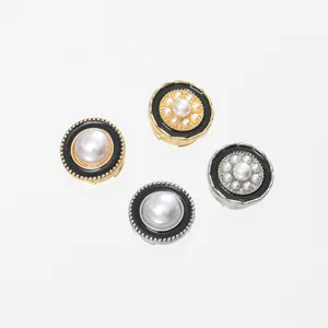Close-up of vintage pearl decorative buttons, exquisite black and gold enamel details.