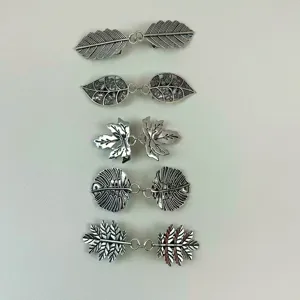 Close up view of exquisite electroplated leaf cardigan clips, detailed metal clothing buckle.