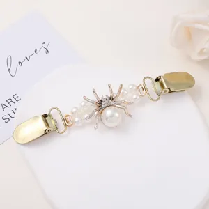 Exquisite pearl and rhinestone spider cardigan clip detail shot, elegant accessory.