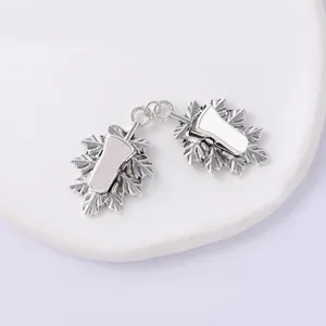 Closeup of vintage silver leaf scarf clips, exquisite metal dual clip details for apparel.