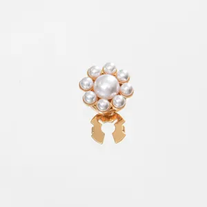 Close-up detail of a pearl flower shirt collar clip and cuff accessory with golden metal.