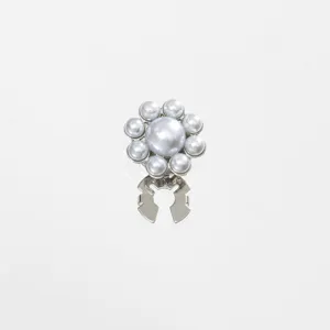 Detailed shot of pearl flower collar clip, silver metal button cover, exquisite fashion accessory.