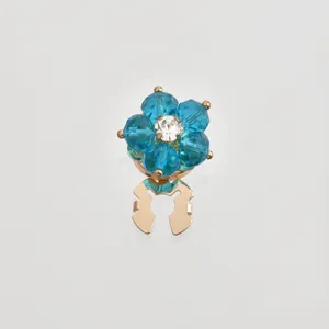 Detailed close-up of blue crystal flower scarf buckle accessory with sparkling rhinestone.