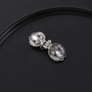 Close-up detail of vintage rhinestone silver scarf clip and brooch collar accessory.