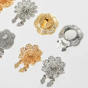 Primo piano di clip per colletto in lega di fiori cavi, squisiti accessori oro e argento.