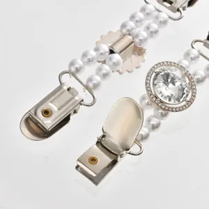 Close-up detail of pearl rhinestone sweater clip, elegant clothing accessory with metal clips.