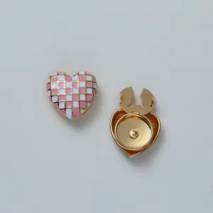 Close-up detail of the pink and white checkered heart enamel cufflink and fastener accessory.