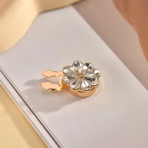 Close-up detail of a glamorous crystal flower cufflink, elegant gold metal base and rhinestones.