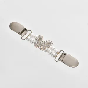Close-up detail of the elegant pearl and rhinestone cardigan clip, featuring metal clasps.