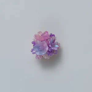 Detail view of the purple resin flower brooch, showcasing intricate bead clusters well.